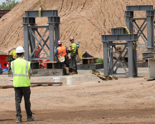 Workers on Construction Site with Equipment that has Equipment Share Tracking